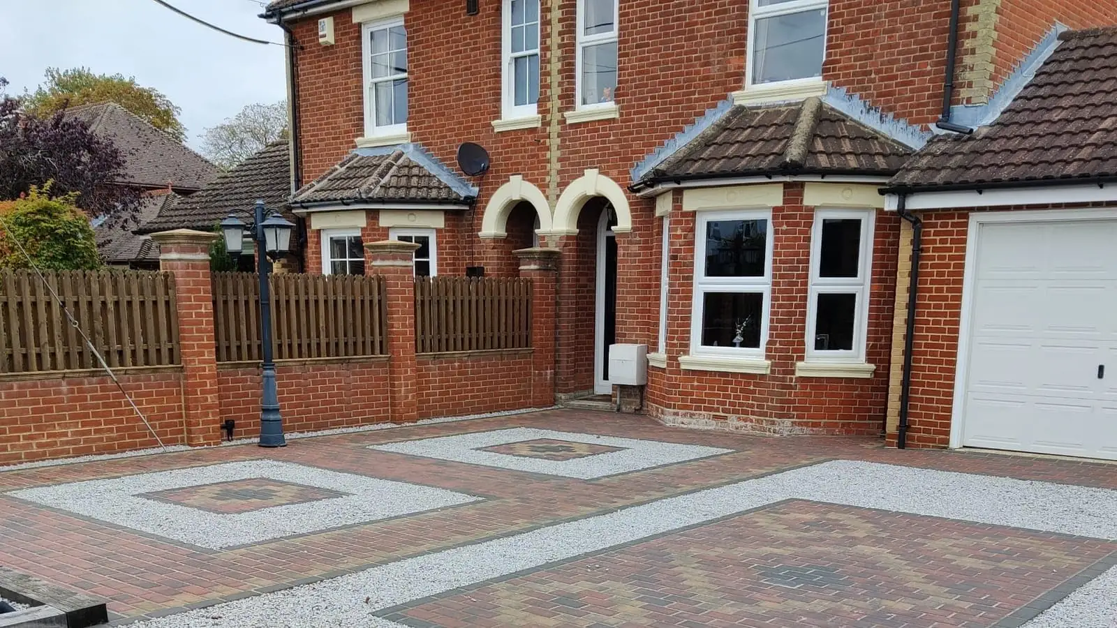 A block paved and gravel driveway at the front of a house