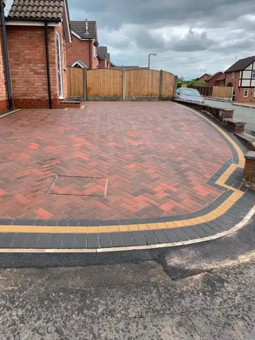 A curved brindle block paved driveway with a charcoal and gold border